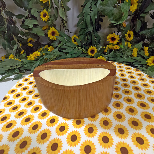 Wooden box with a light inside on a sunflower-patterned tablecloth with greenery in the background