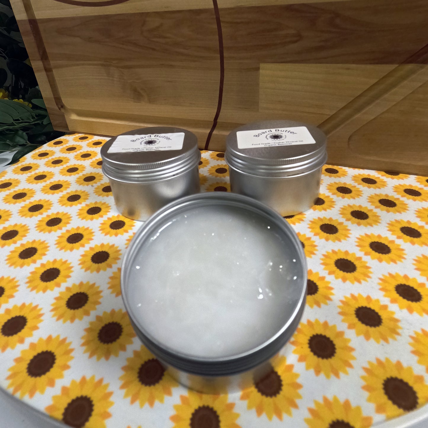 Three metal tins with lids on a tablecloth with sunflower pattern