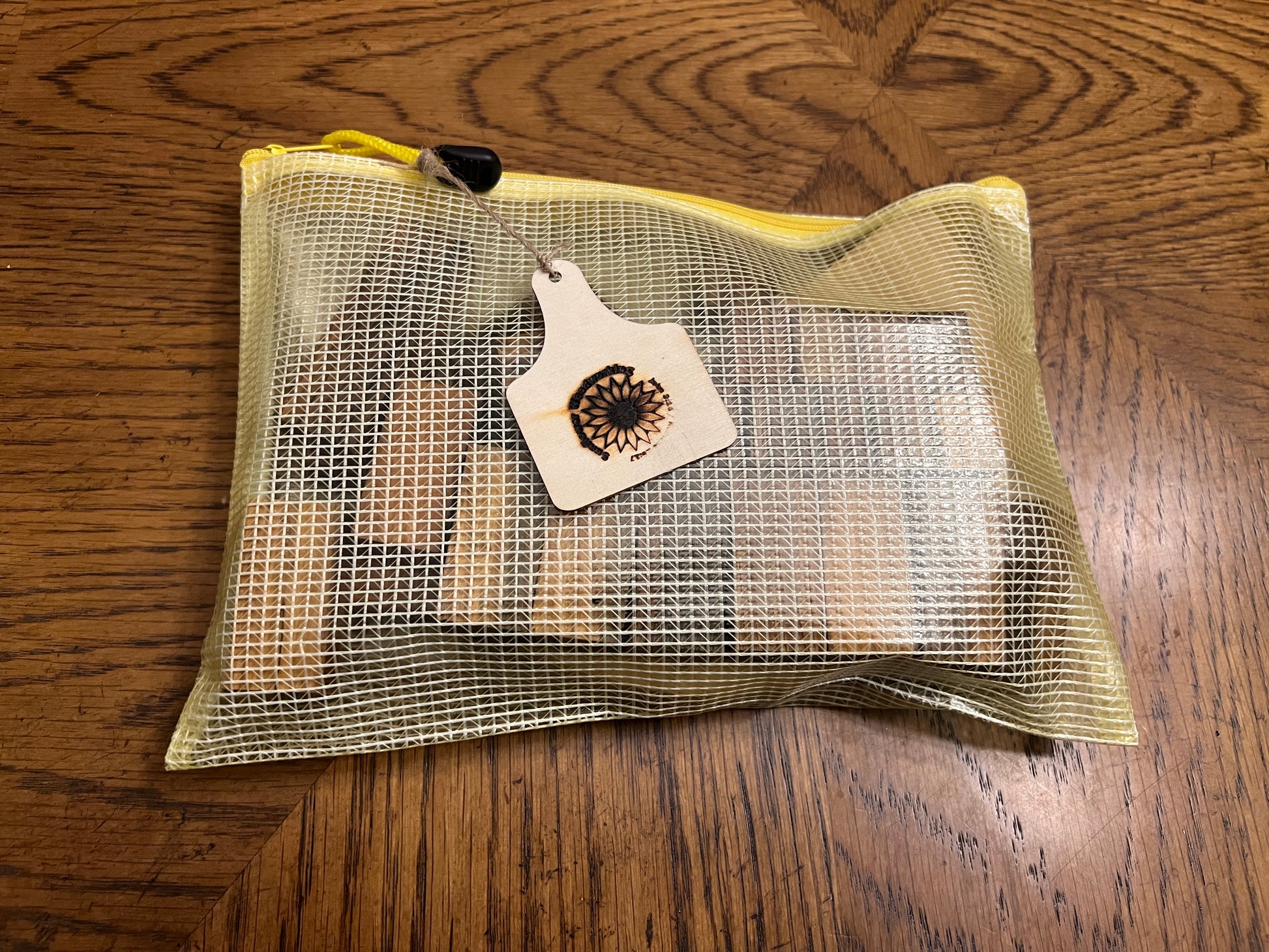 Mesh bag with a small tool on a wooden surface