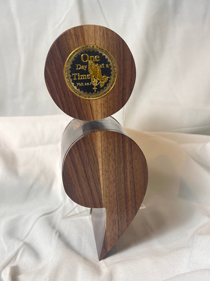 A black walnut semicolon keepsake box with a gold and black "One Day at a Time" coin embedded on the top.