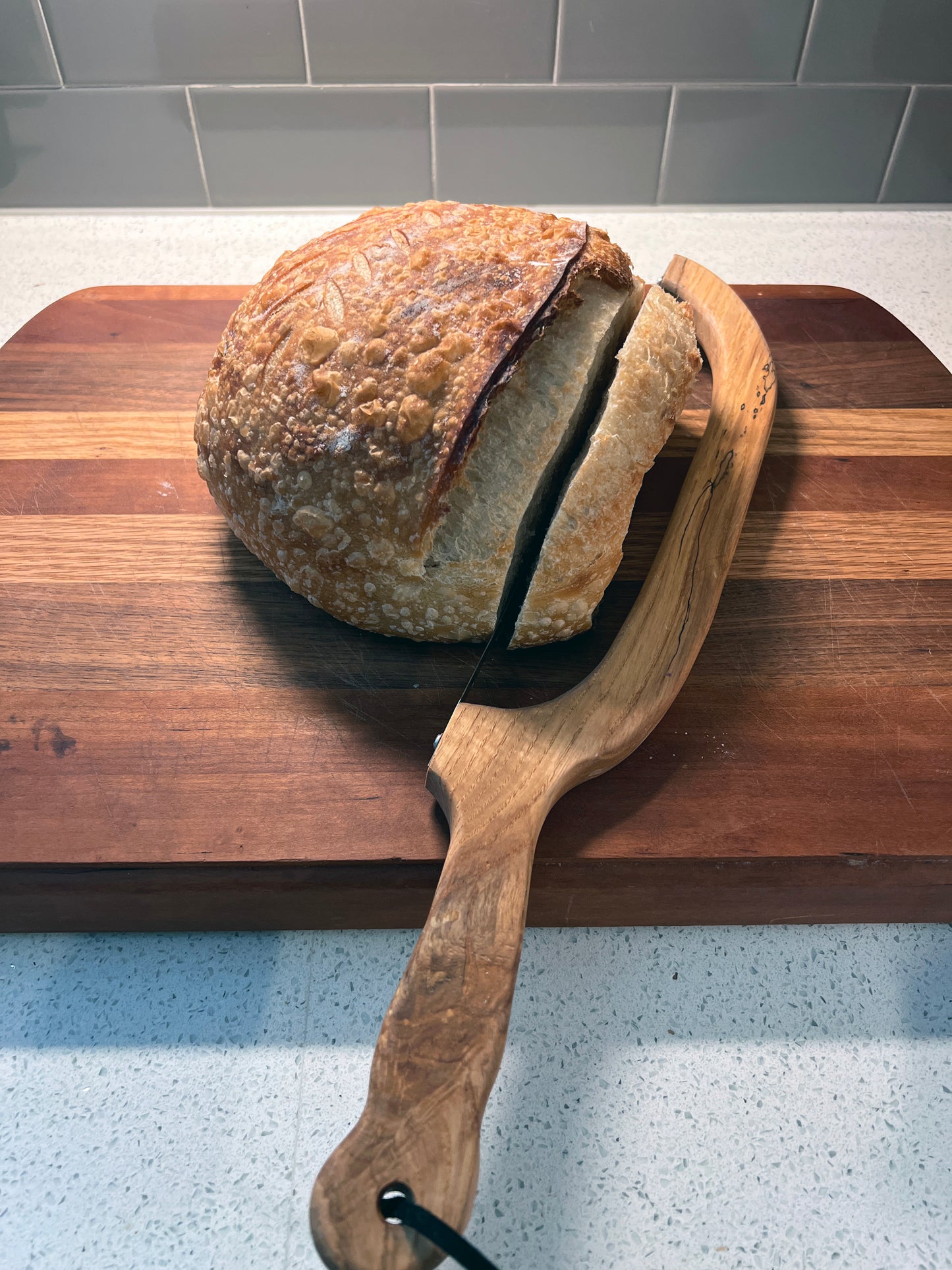 Loaf of bread on a wooden board with a bread knife