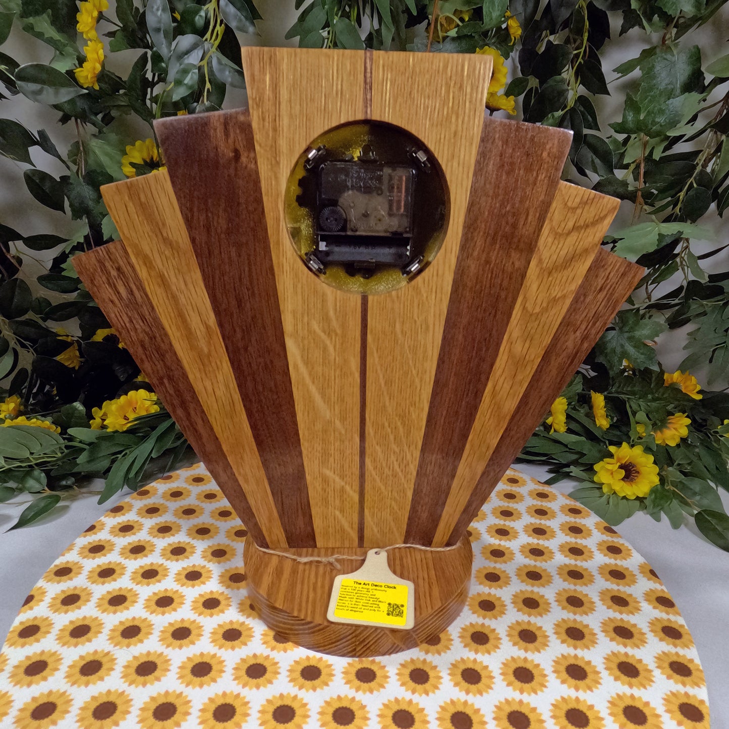 Wooden clock with a circular design on a tablecloth with sunflower pattern