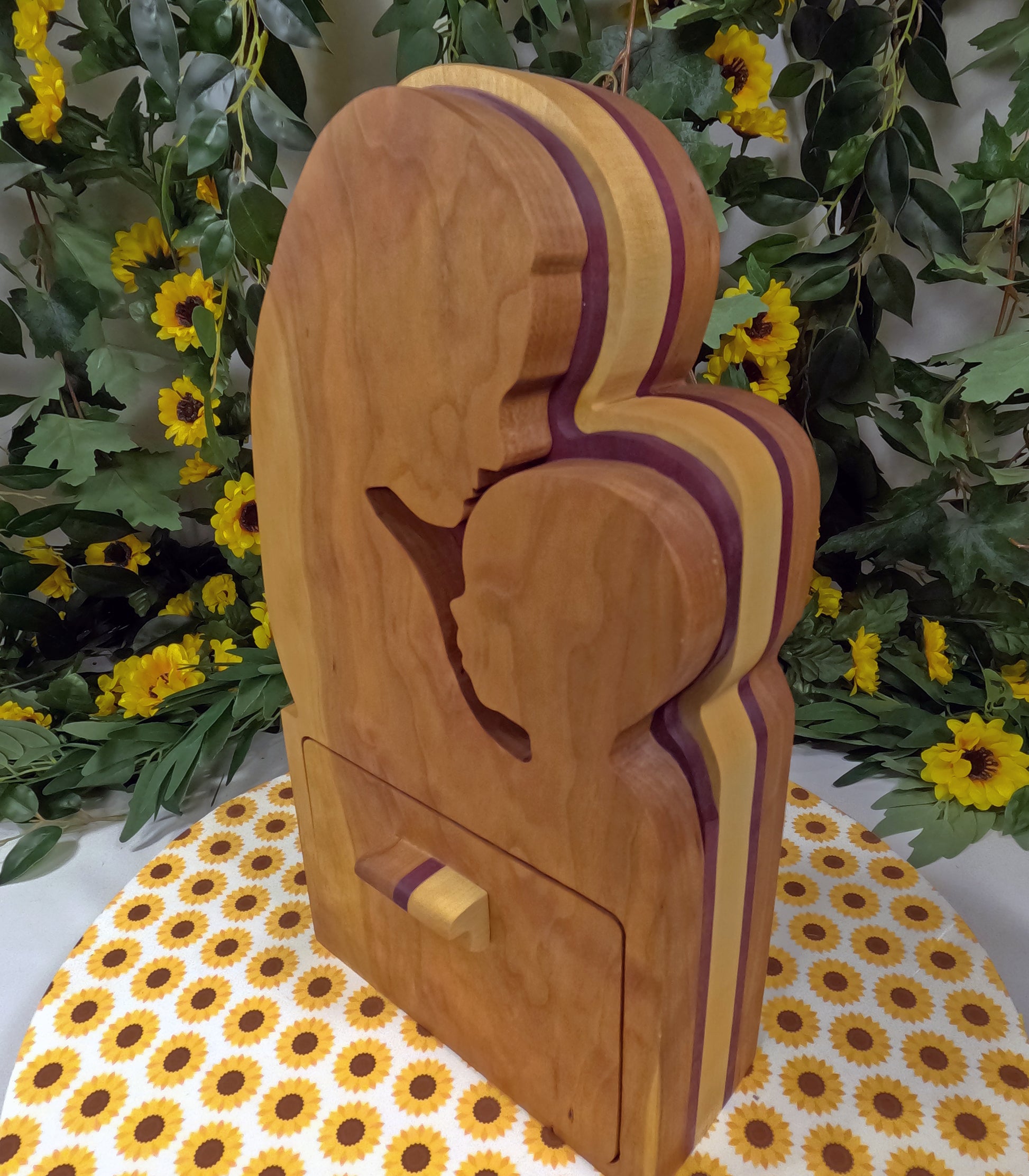 Wooden sculpture of a couple with a drawer on a floral tablecloth