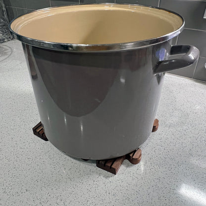 Large metal pot with beige interior on a speckled countertop