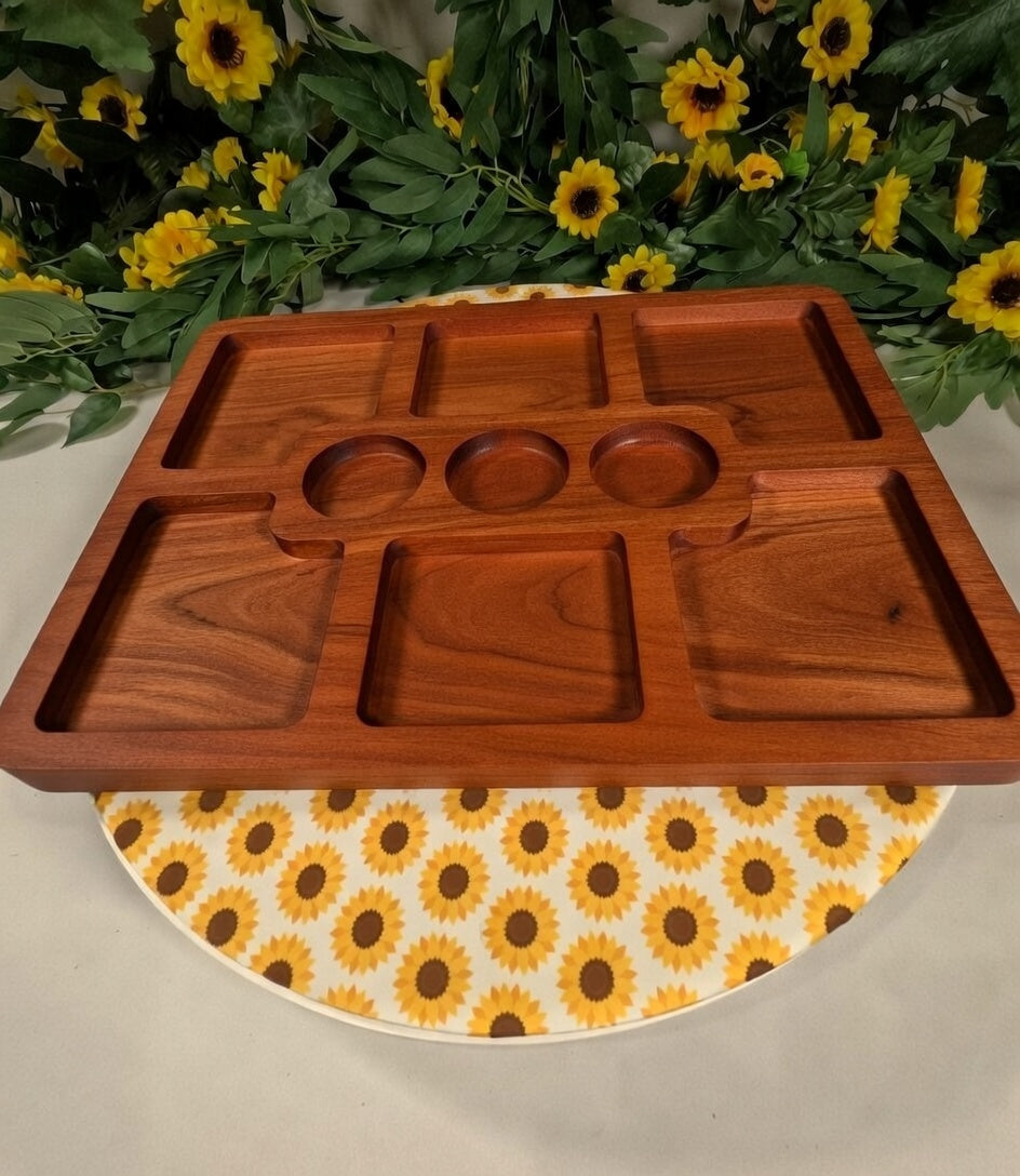 Wooden tray on a plate with sunflower pattern, surrounded by sunflowers and greenery