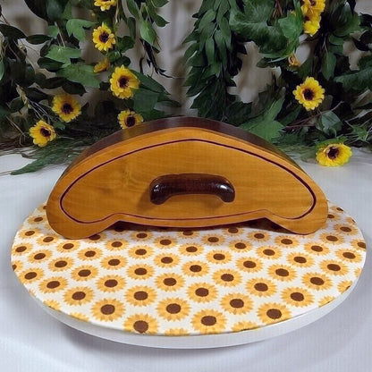 Wooden box on a sunflower-patterned dish with greenery and flowers in the background