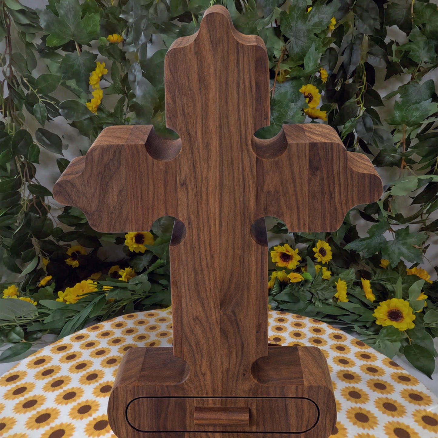 Wooden cross-shaped object on a table with a floral background