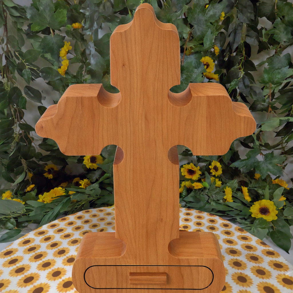 Wooden cross-shaped object on a tablecloth with floral background