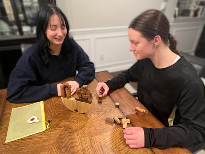 Two girls sitting at a table playing a game