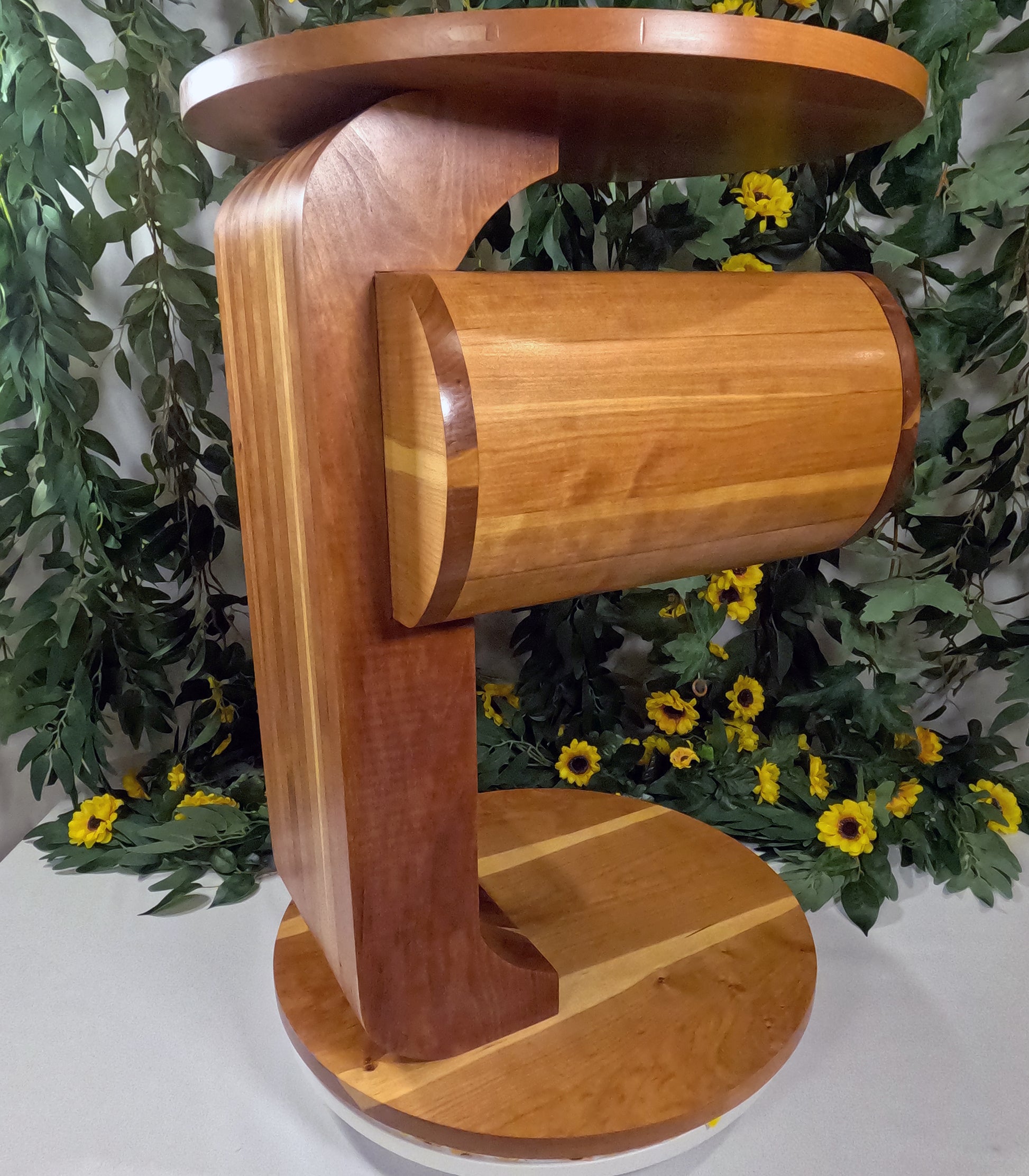 Wooden side table with a cylindrical design against a floral background