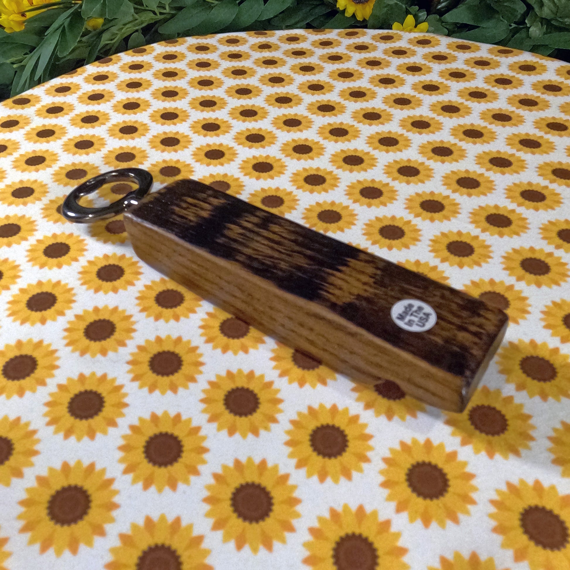 Wooden bottle opener on a sunflower-patterned fabric