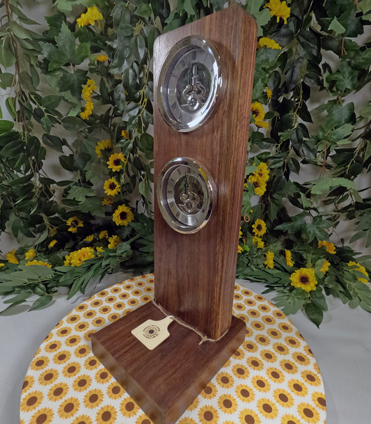 Wooden clock with silver circular faces on a floral-patterned tablecloth