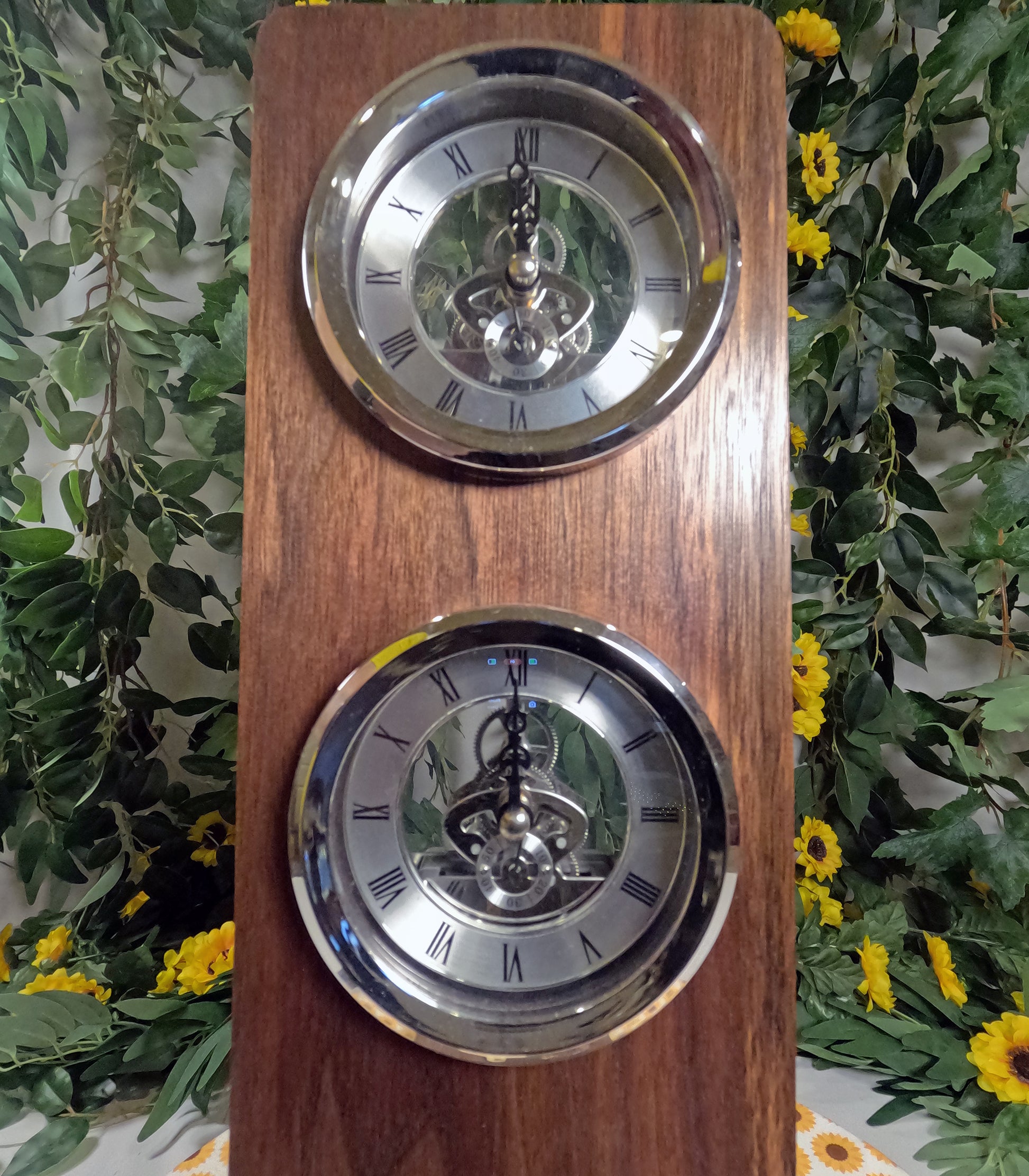 Wooden clock with two silver faces against a floral background