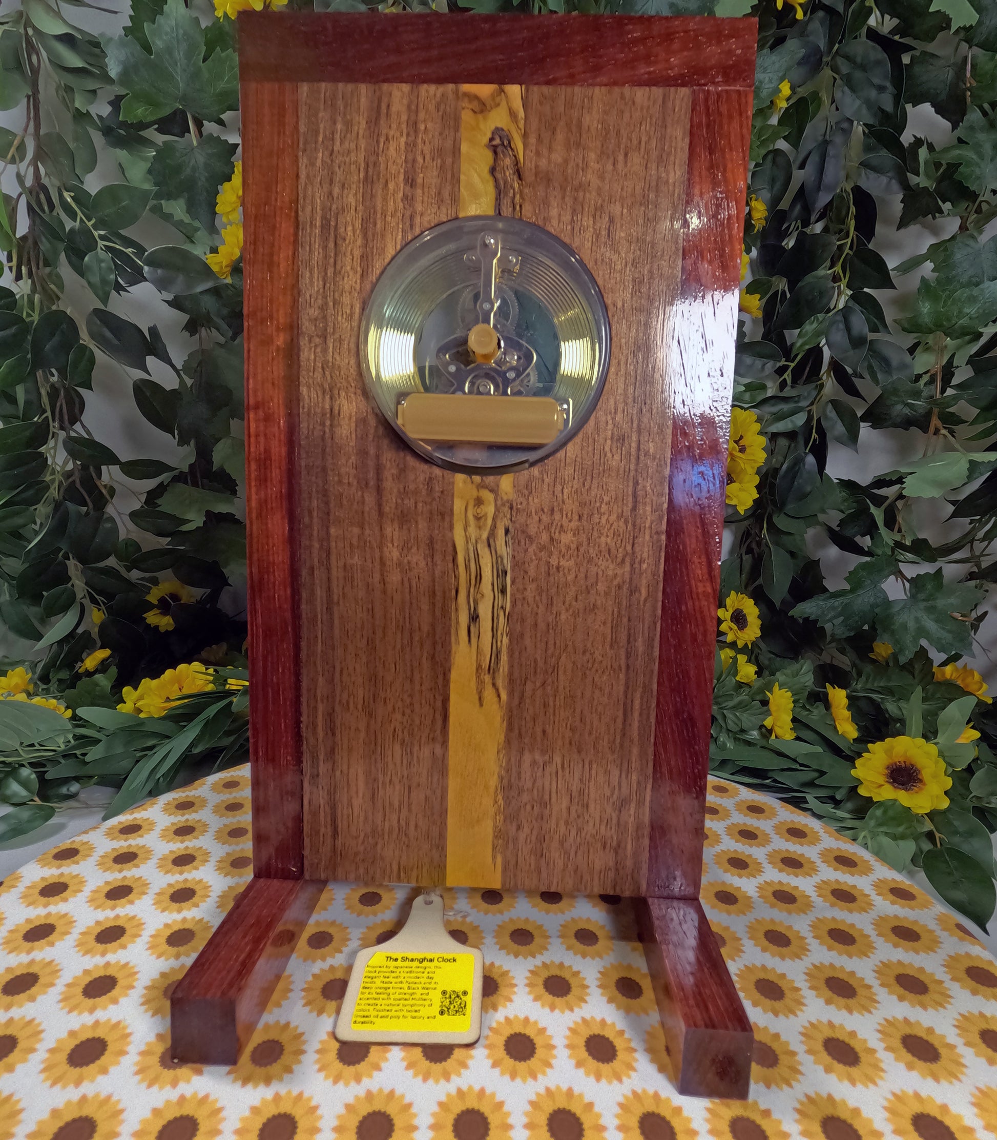 Wooden clock with decorative elements on a floral tablecloth