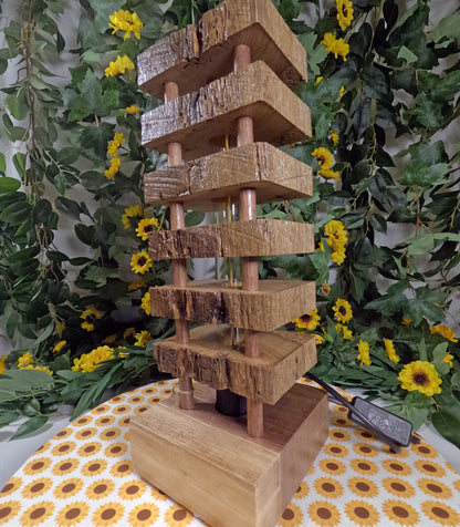 Wooden tiered light on a table with floral and greenery background
