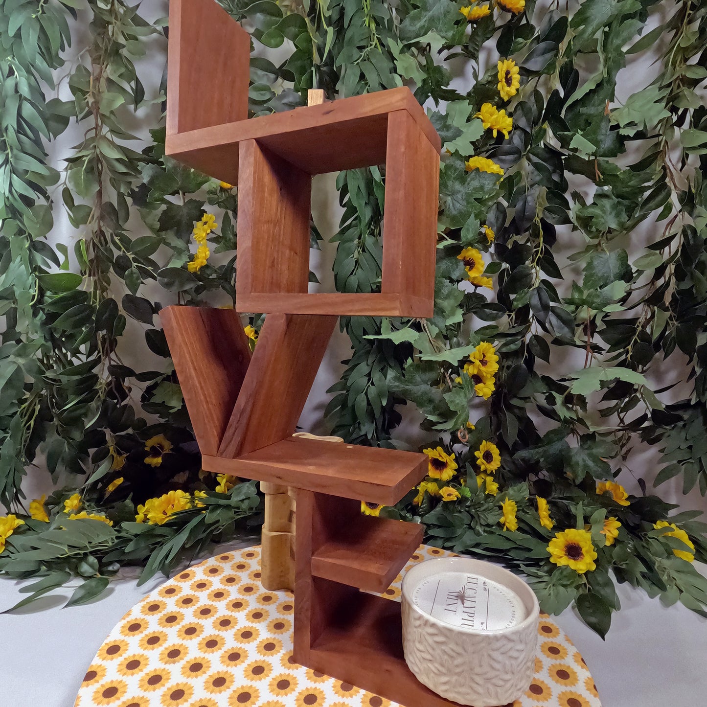 Wooden shelf with a candle on a floral background