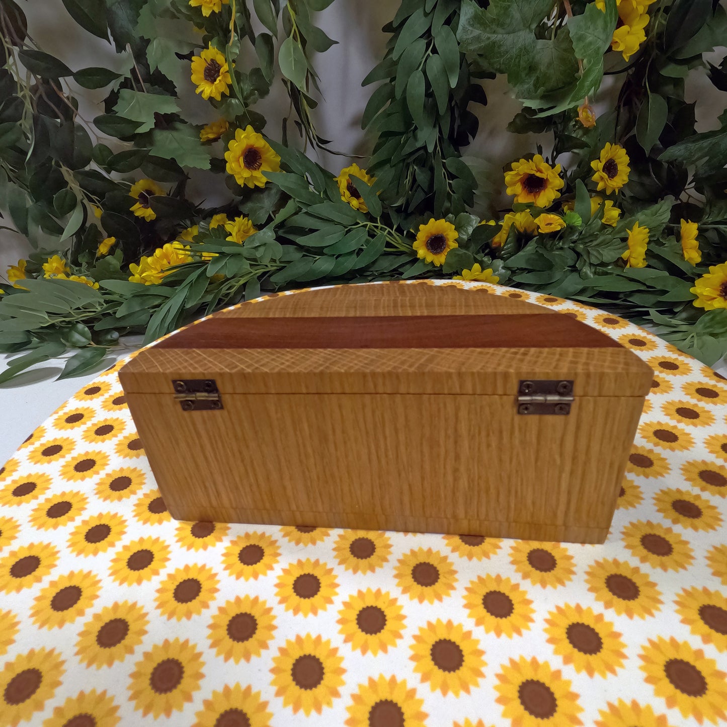 Wooden box on a tablecloth with sunflower pattern and floral background