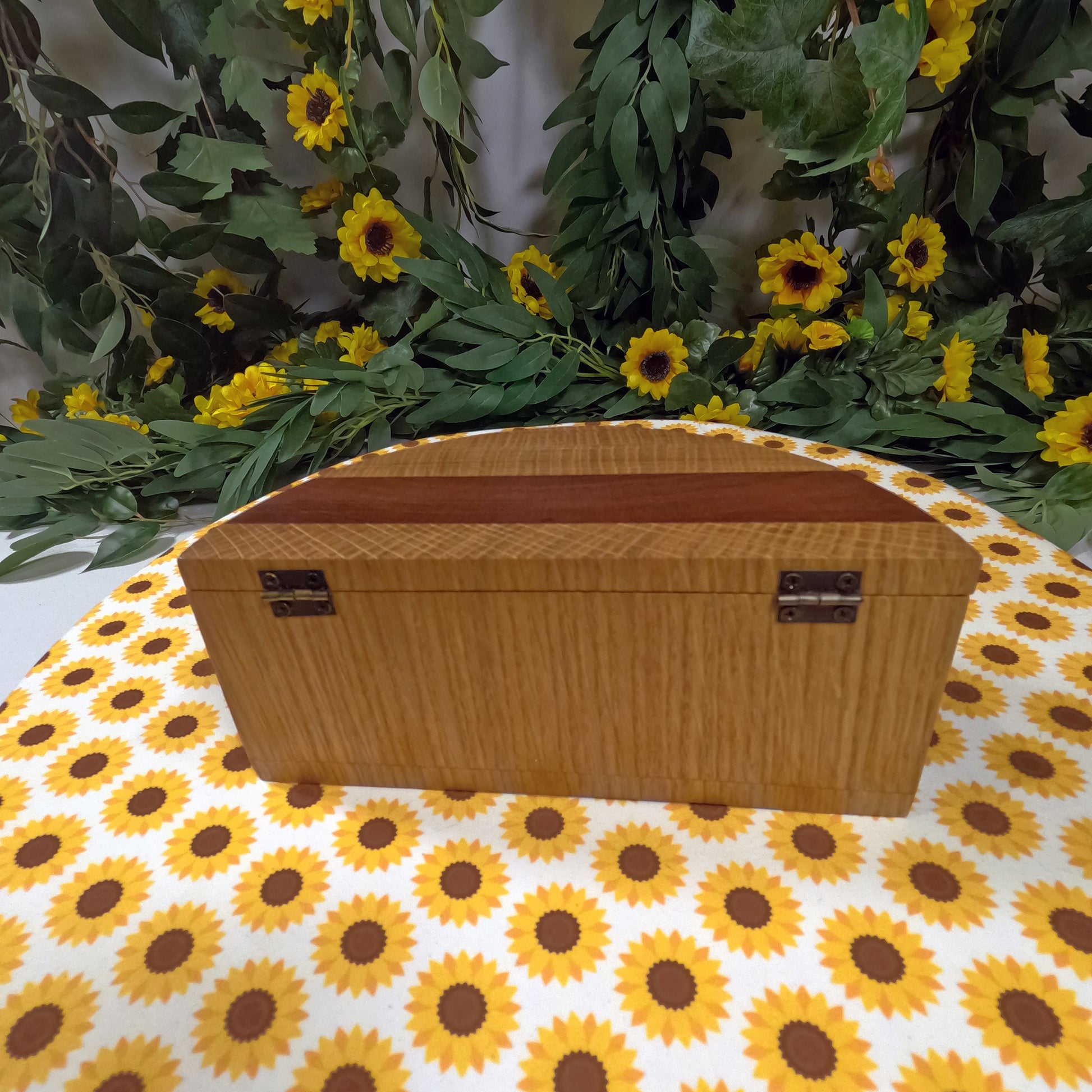 Wooden box on a tablecloth with sunflower pattern and floral background