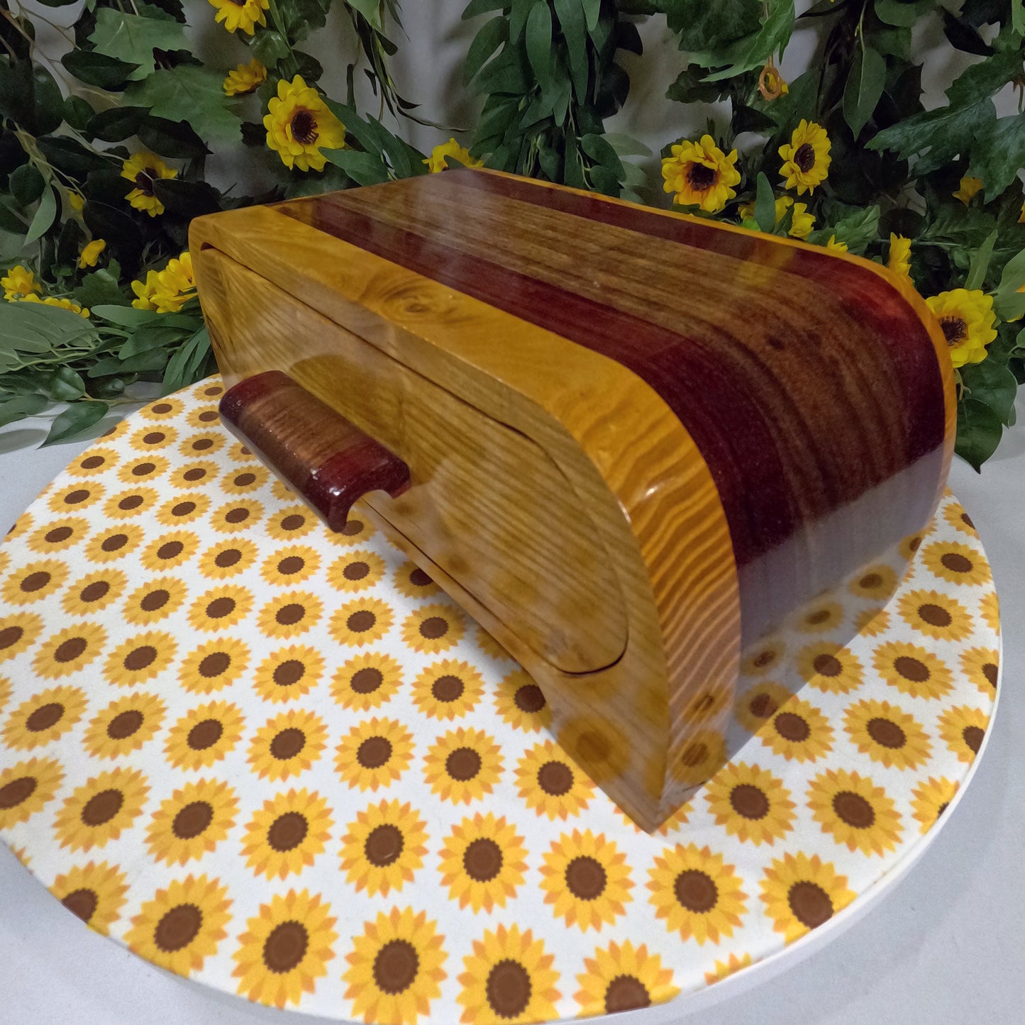 Wooden box with wavy design on a sunflower-patterned tablecloth