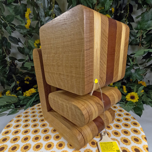 Wooden jewelry box on a table with a floral tablecloth and greenery in the background