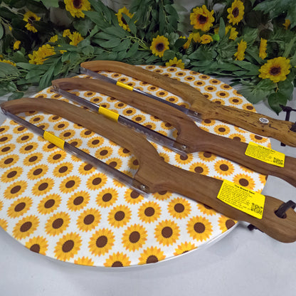 Wooden saws on a sunflower-patterned ironing board with greenery in the background