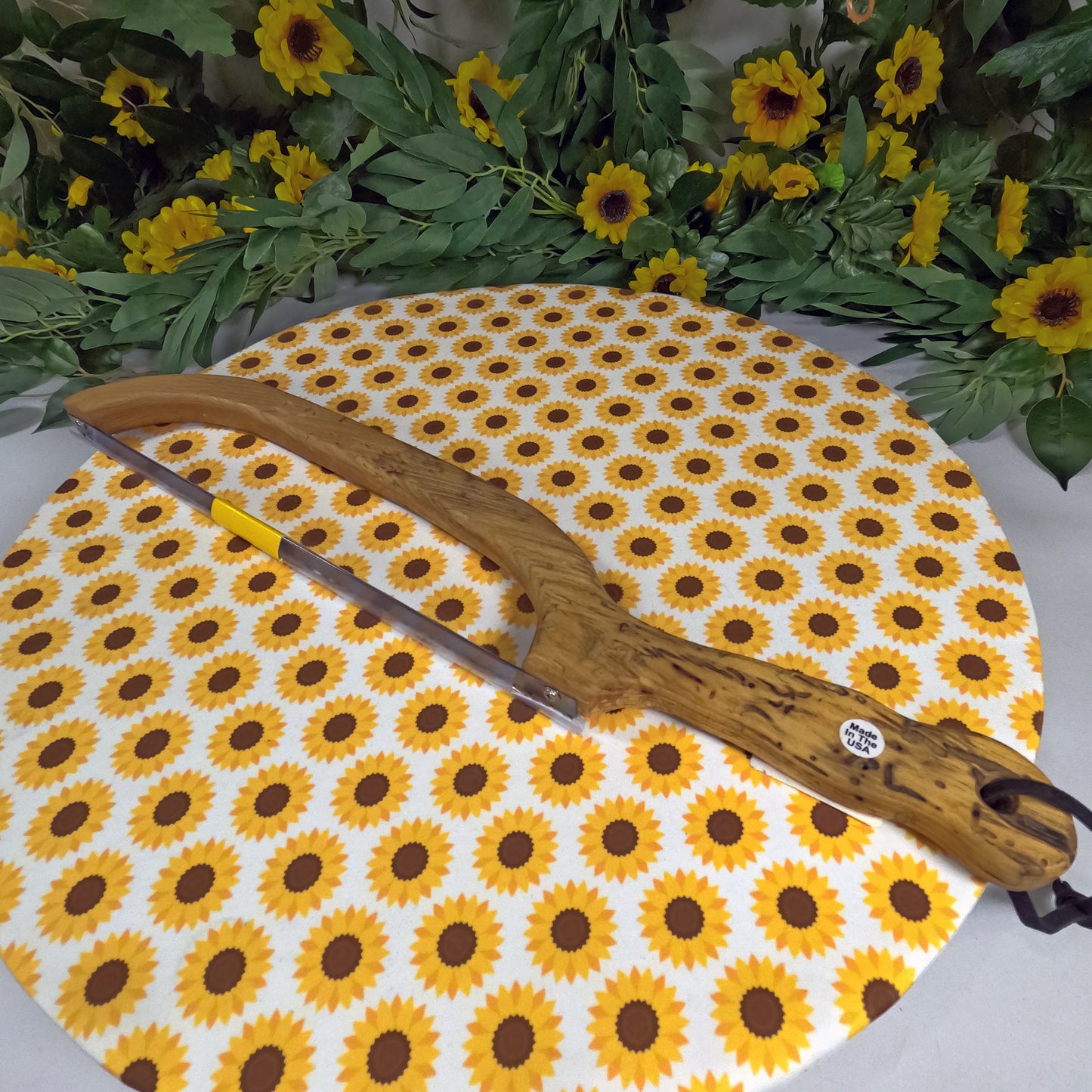 Saw on a sunflower-patterned mat with flowers and leaves in the background