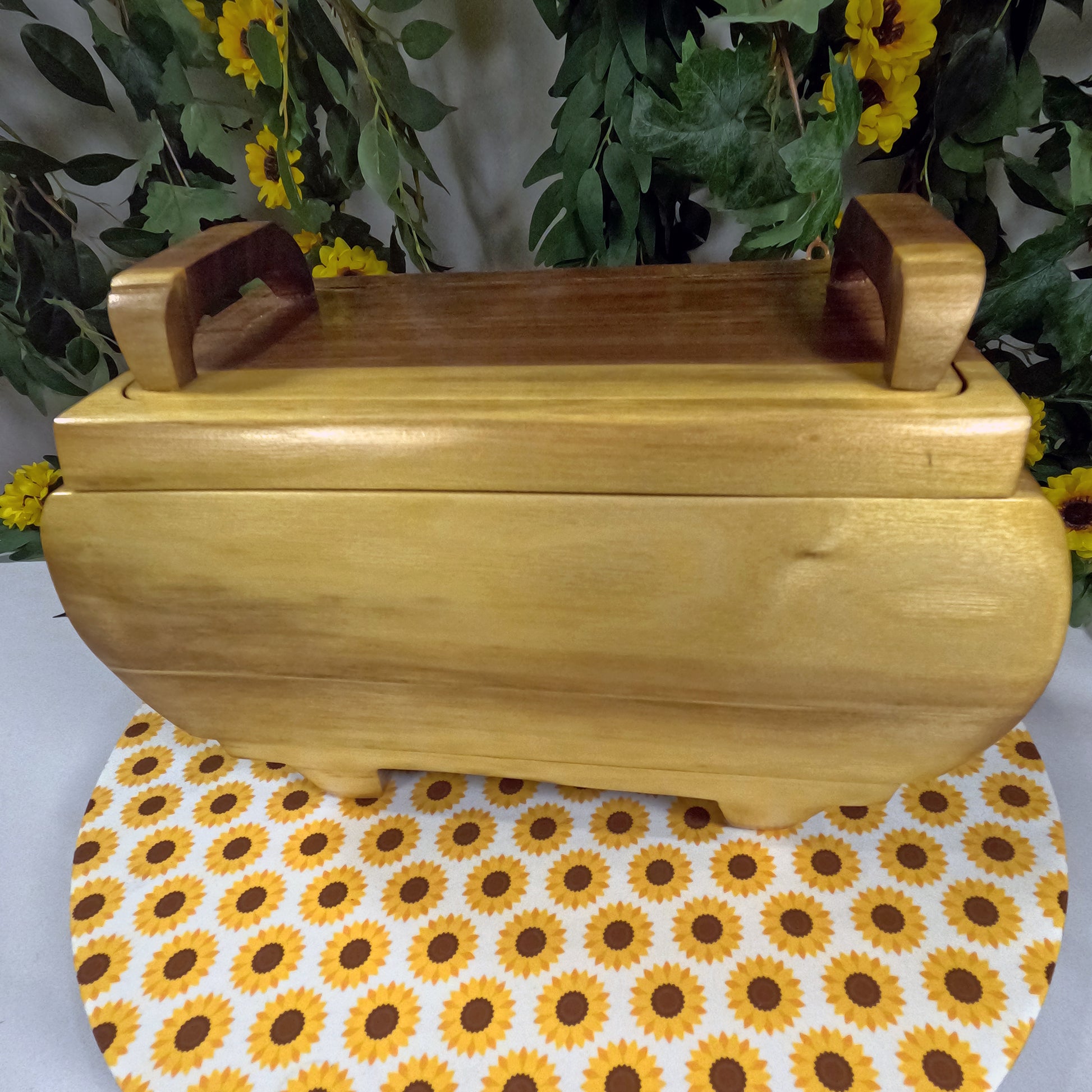Wooden box with handles on a sunflower-patterned tablecloth