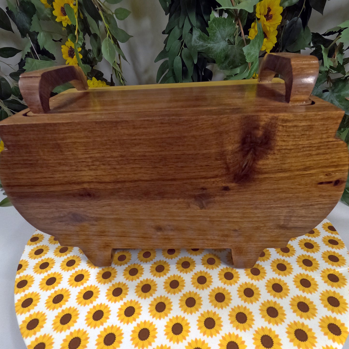 Wooden box with handles on a sunflower-patterned surface