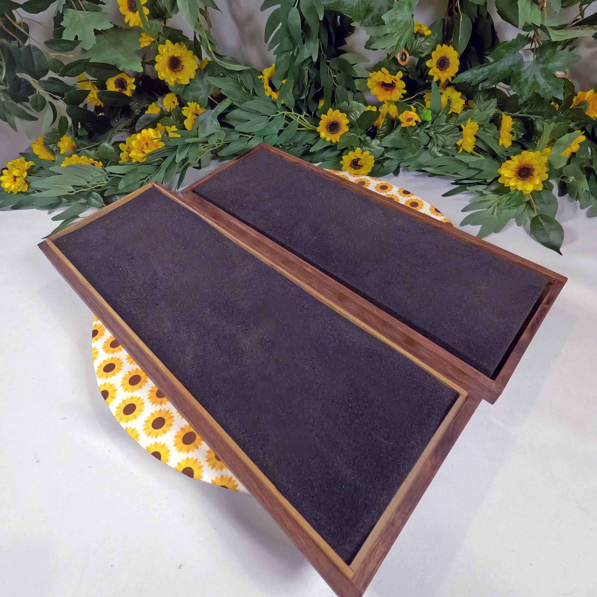 Wooden box on a white surface with sunflower decorations.