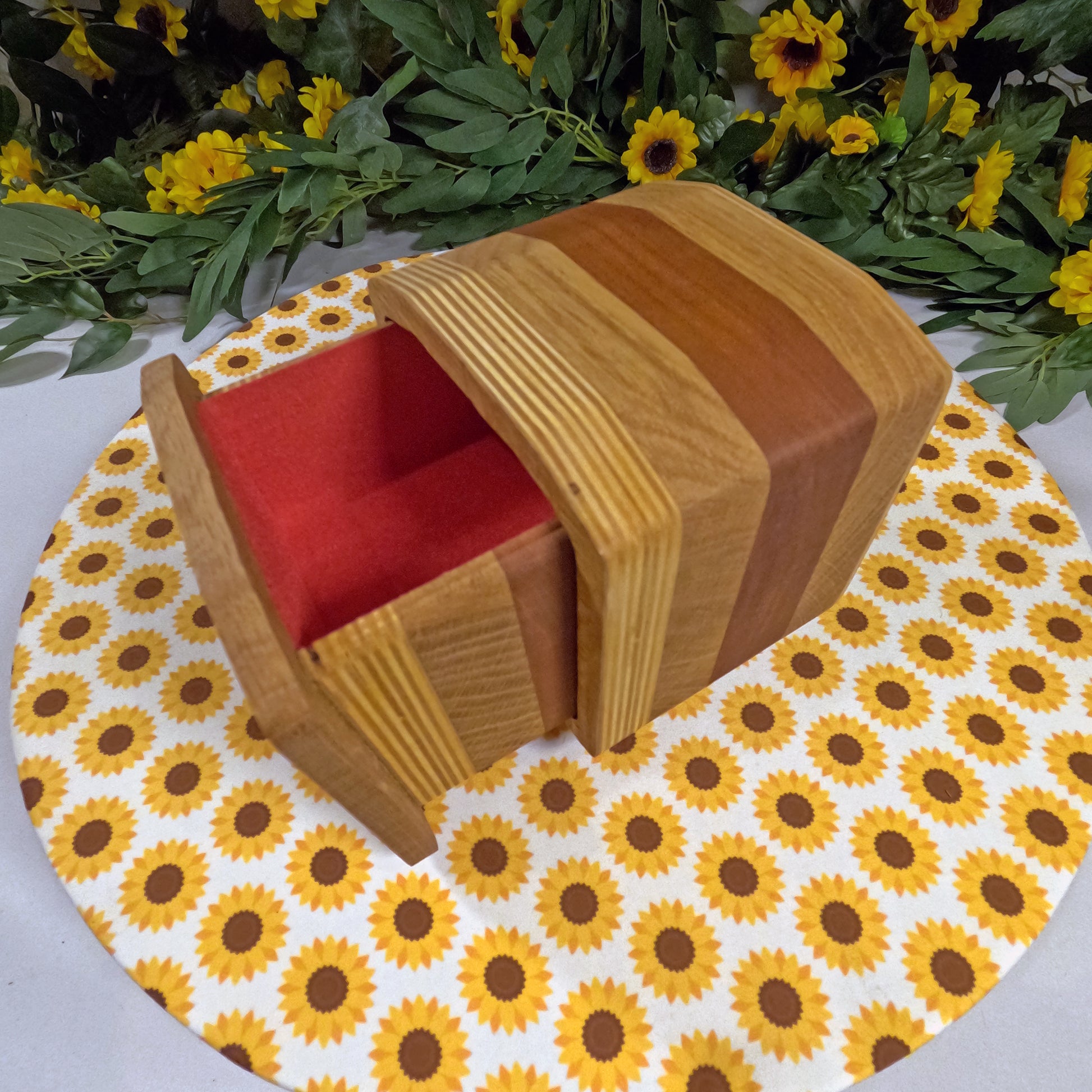 Wooden box with red interior on a sunflower-patterned mat