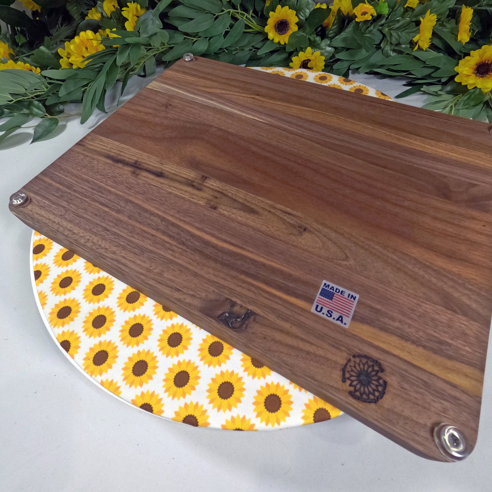 Wooden cutting board with 'Made in U.S.A.' label on a floral background