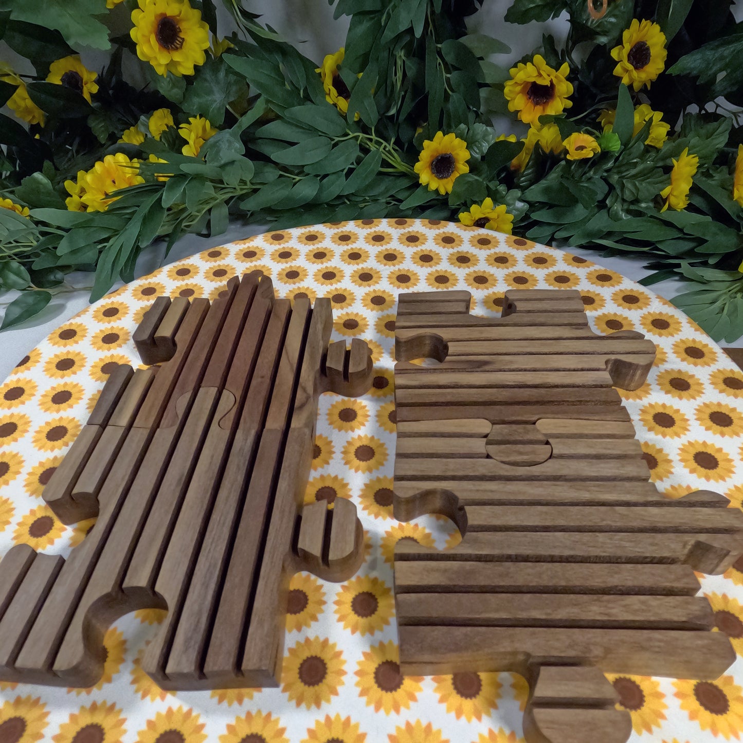 Wooden puzzle trivets on a tablecloth with sunflower pattern