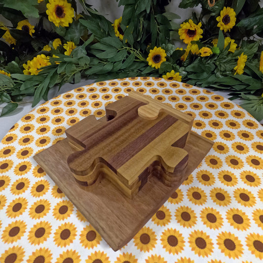 Wooden puzzle coasters on a sunflower-patterned tablecloth with floral decorations.