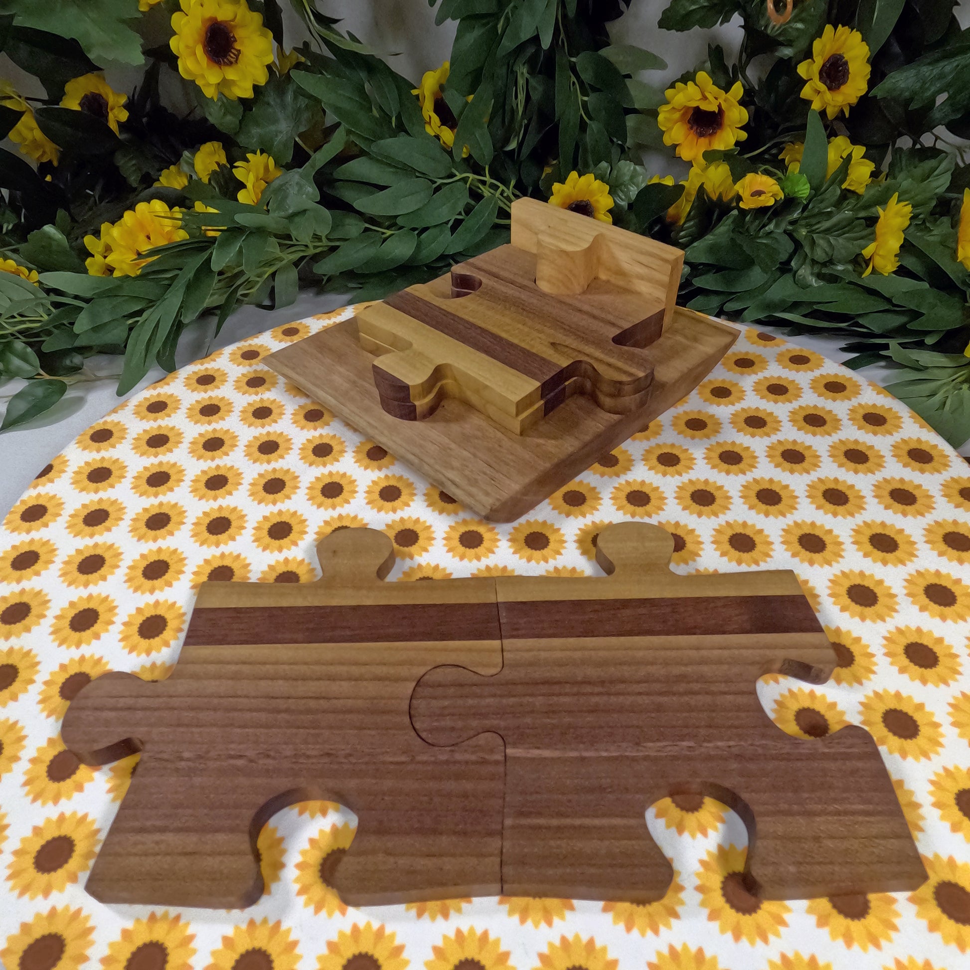 Wooden puzzle coasters on a floral tablecloth with sunflowers
