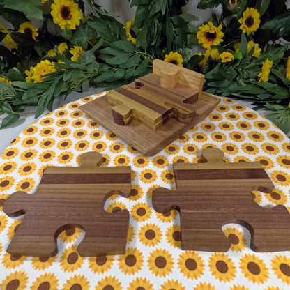 Wooden puzzle coasters on a tablecloth with sunflower pattern, surrounded by sunflowers and greenery.