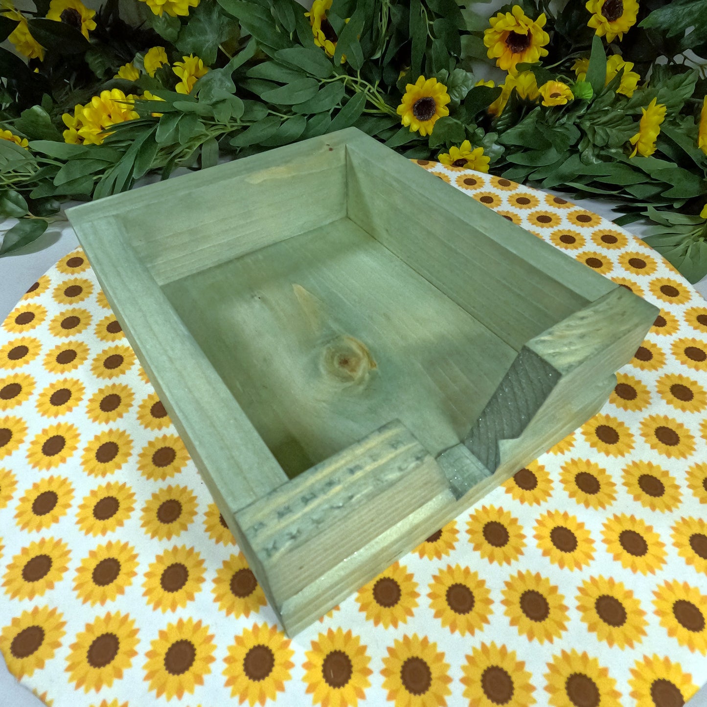 Wooden box on a tablecloth with sunflower pattern