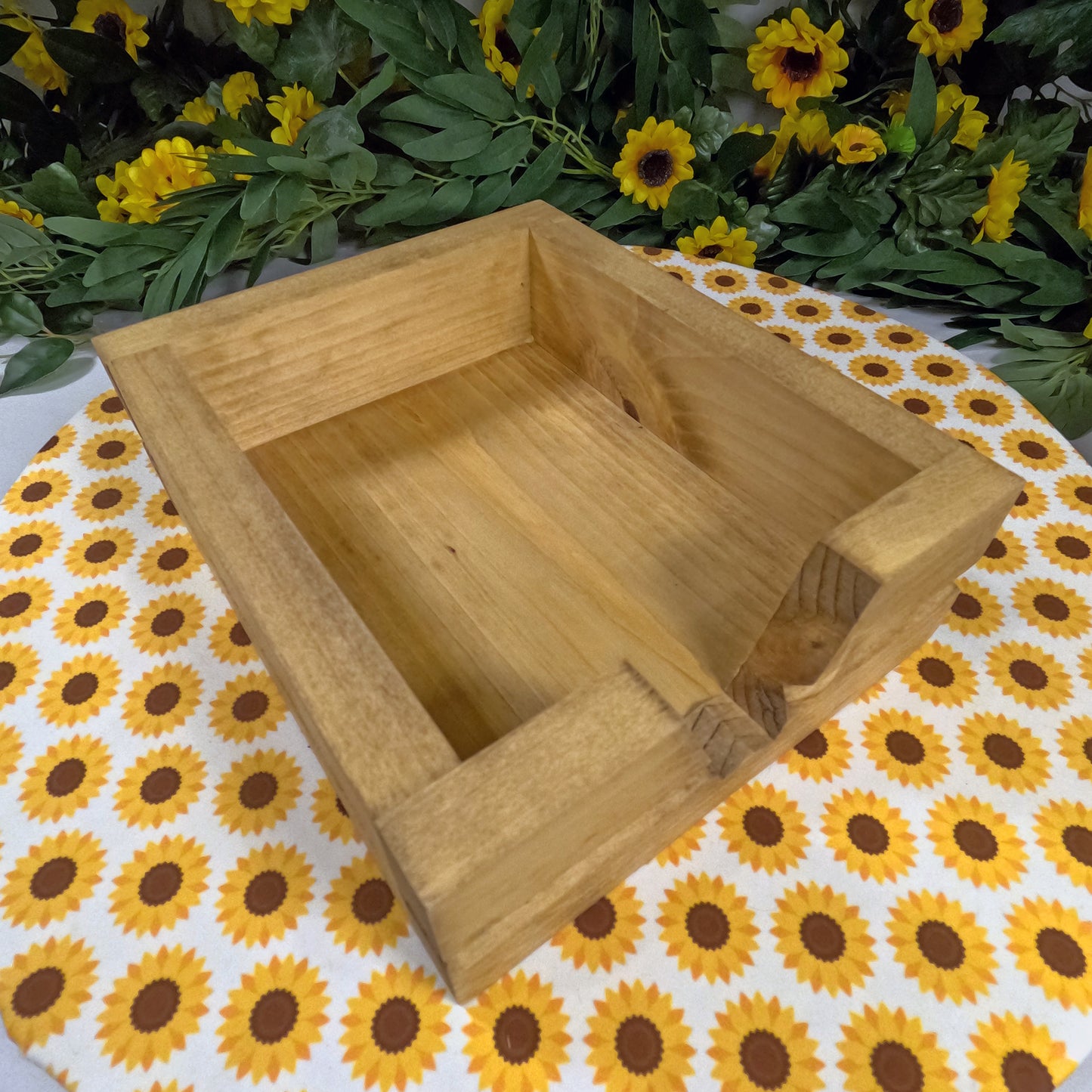 Wooden box on a tablecloth with sunflower pattern