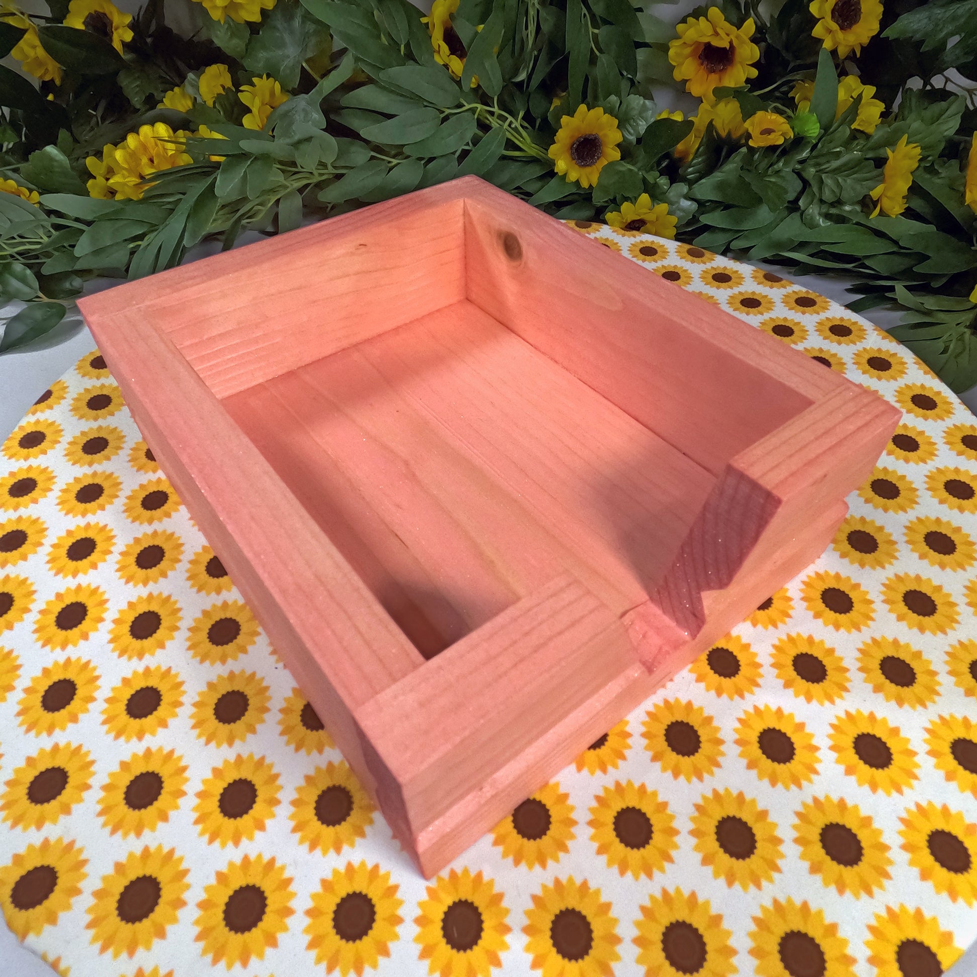 Wooden box on a tablecloth with sunflower pattern