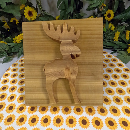 Wooden moose cutout on a floral-patterned tablecloth