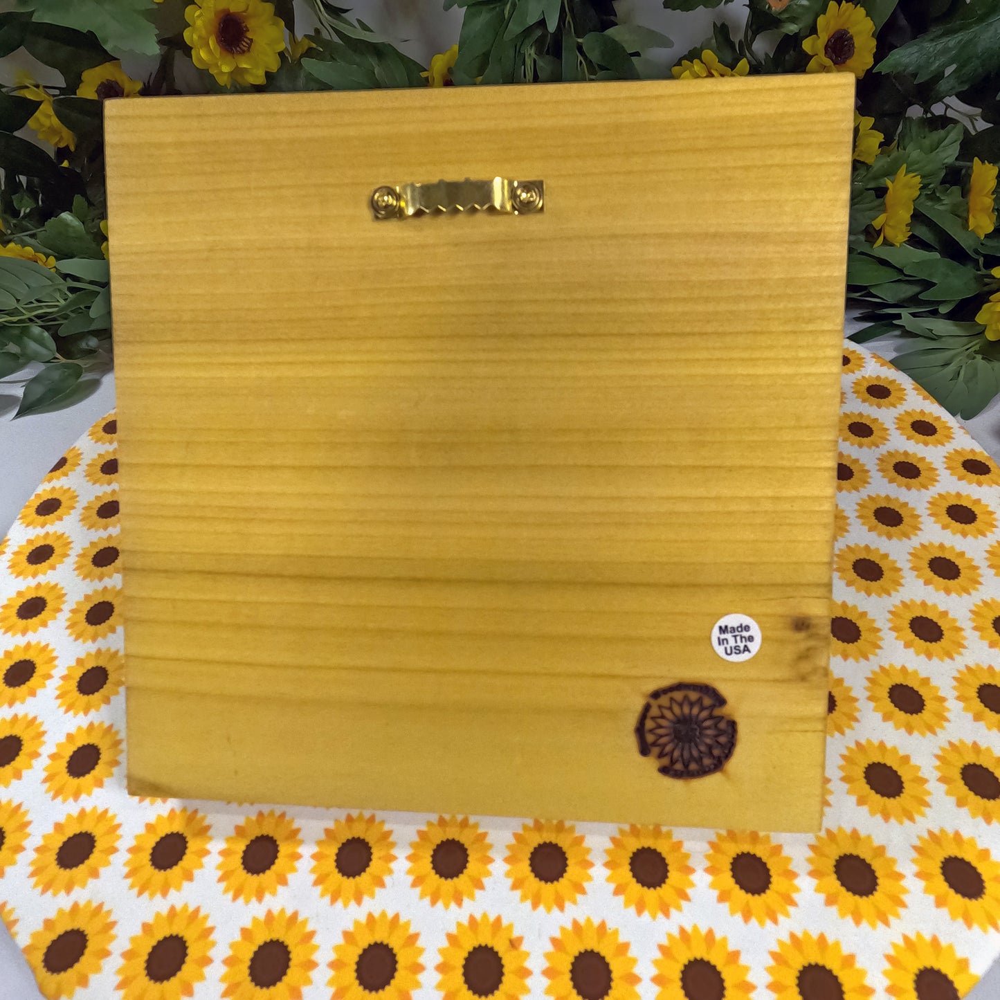 Wooden block with a gold handle on a sunflower-patterned surface