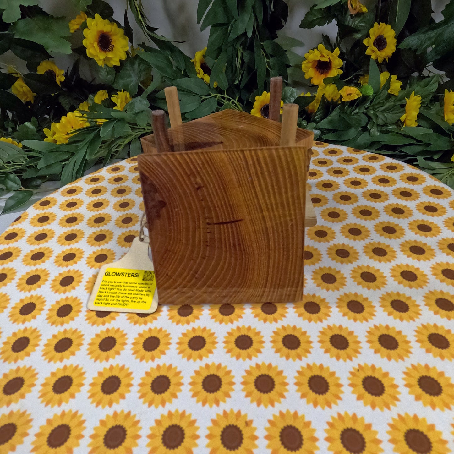 Wooden coasters on a tablecloth with sunflower pattern