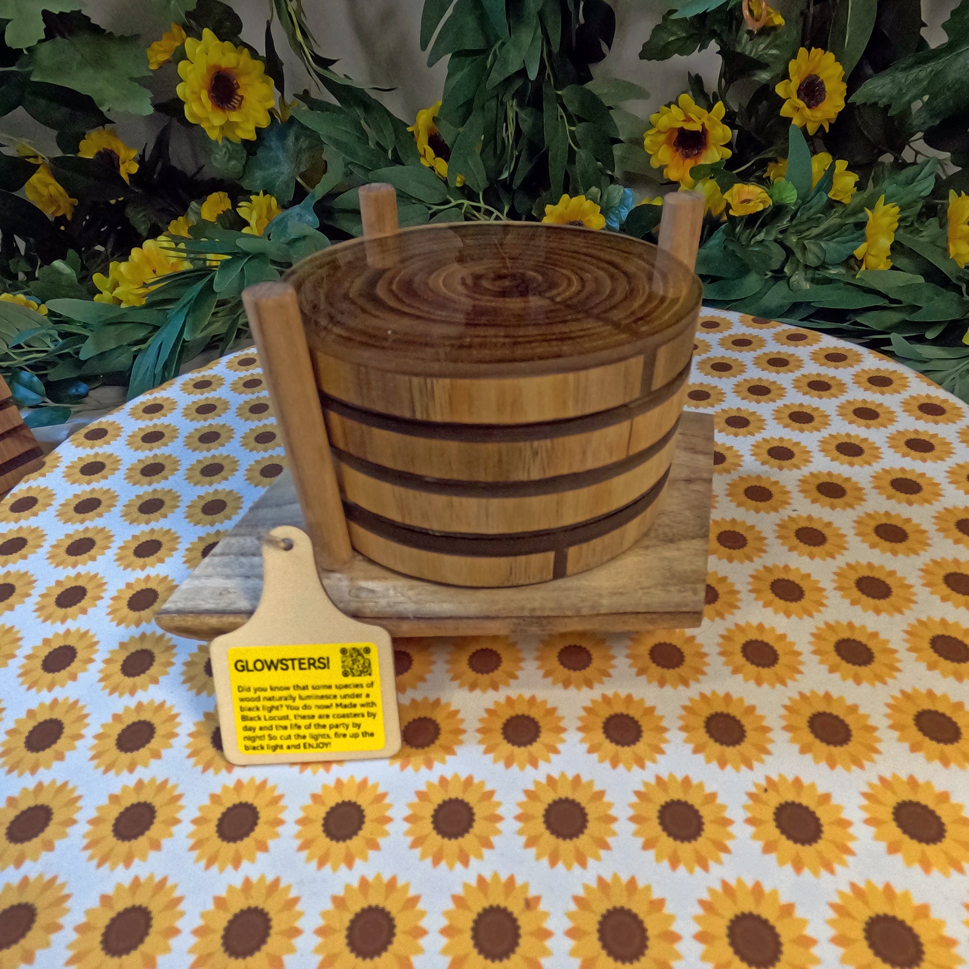 Wooden coasters on a tablecloth with sunflower pattern