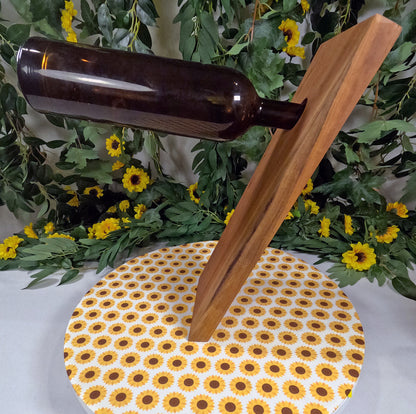 Wooden stand opener on a sunflower-patterned coaster with a bottle in the background.