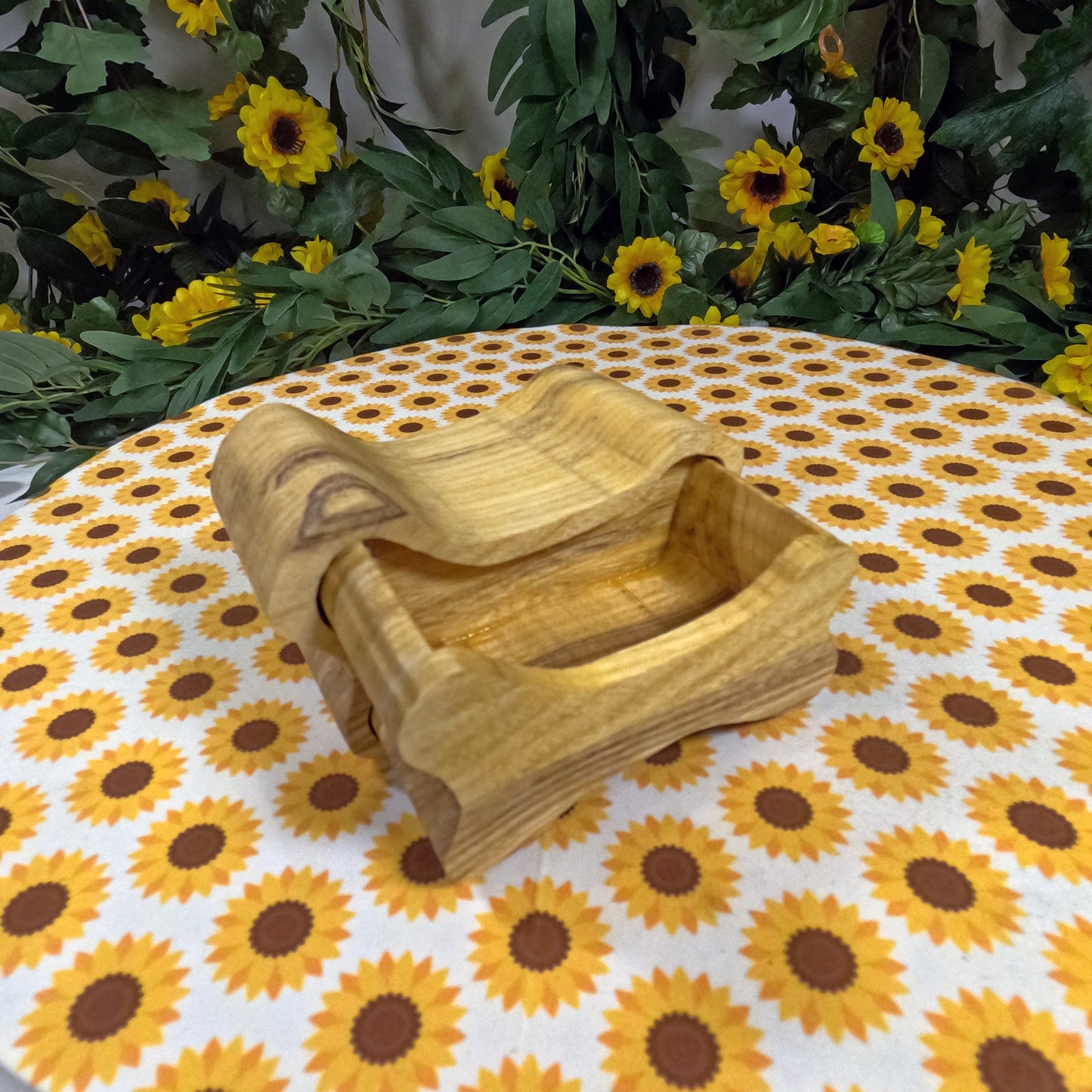 Wooden dog bone-shaped box on a tablecloth with sunflower pattern