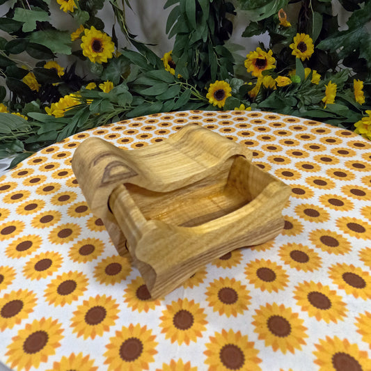 Wooden dog bone-shaped box on a tablecloth with sunflower pattern