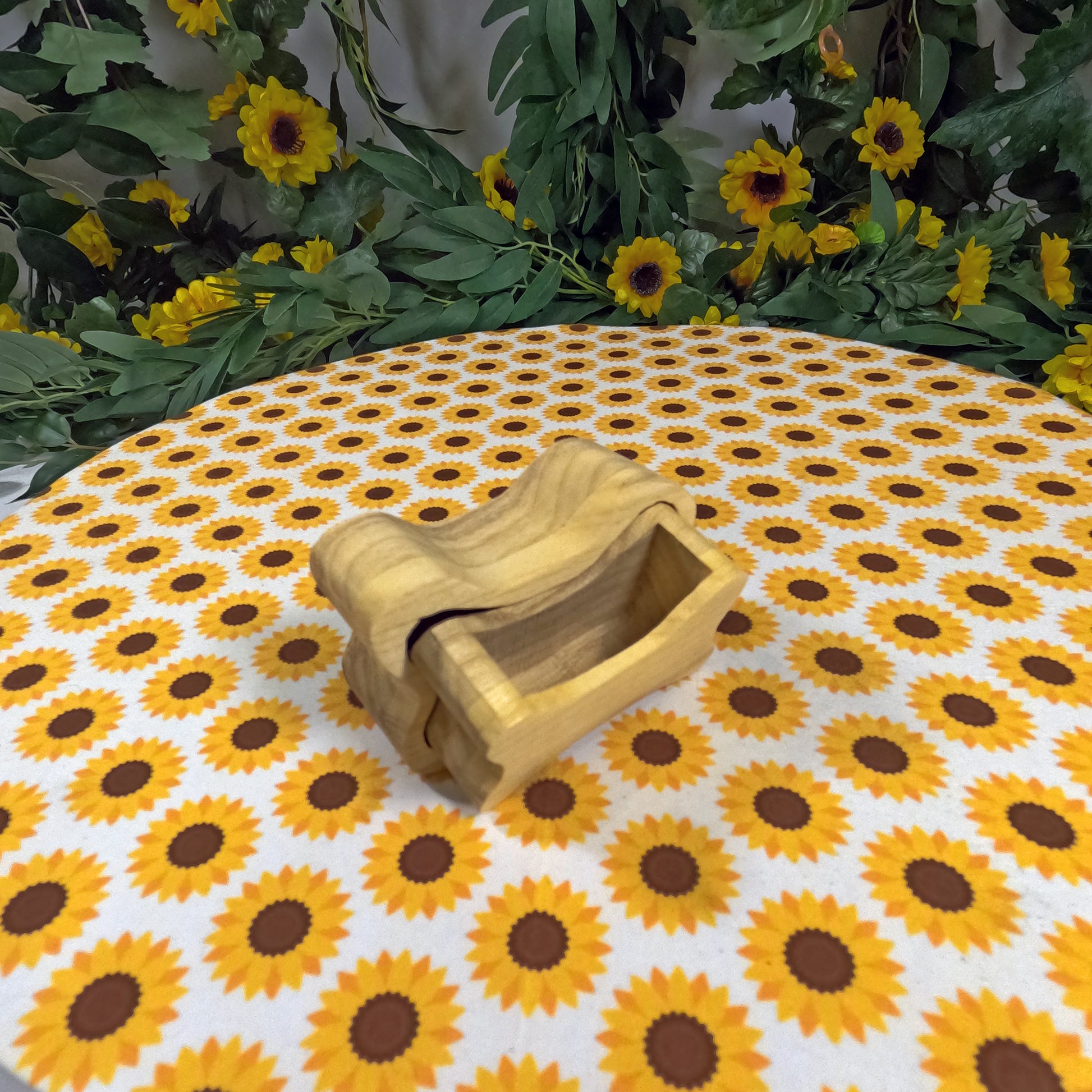 Wooden dog bone-shaped box on a tablecloth with sunflower pattern