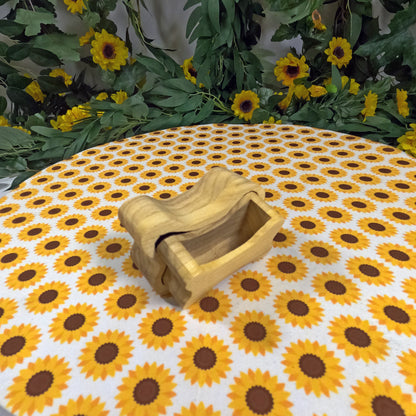 Wooden dog bone-shaped box on a tablecloth with sunflower pattern