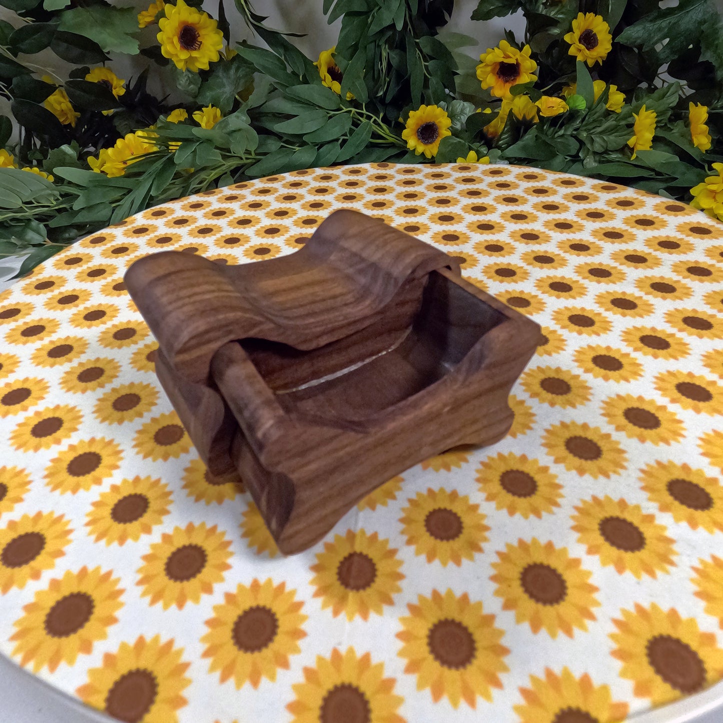 Wooden dog bone-shaped box on a tablecloth with sunflower pattern