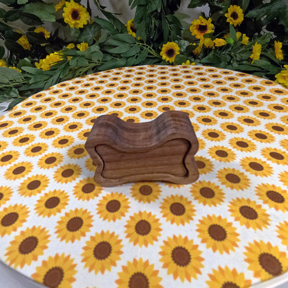 Wooden dog bone-shaped box on a tablecloth with sunflower pattern