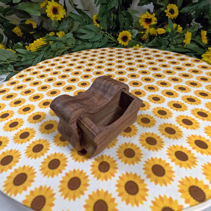 Wooden dog bone-shaped box on a tablecloth with sunflower pattern